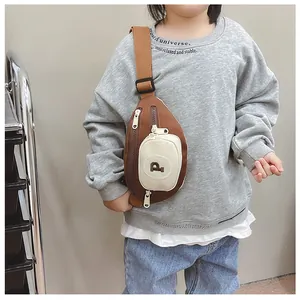 Close-up of kids chest bag featuring a brown and cream color block design and wide strap