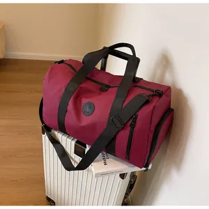 Close-up of burgundy travel bag with shoe compartment on luggage in a travel setting