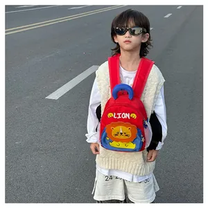 Kid back view showing cartoon lion schoolbag with red straps and blue side mesh pocket