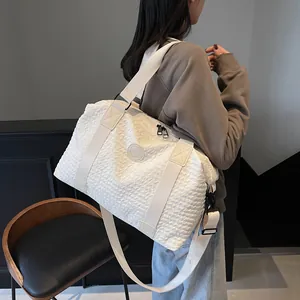 Detail of white bubble texture travel bag with round logo and adjustable shoulder strap