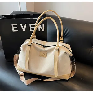 Close-up of cream canvas tote bag with yellow leather details and MNGJIA logo