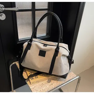 Detail of canvas travel bag with black leather base and adjustable crossbody strap