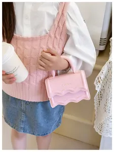 Vue détaillée du mini sac à bandoulière rose avec bords ondulés et poignée chic