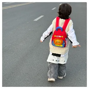 Rear view of a child wearing the cute red cartoon lion backpack in an outdoor setting