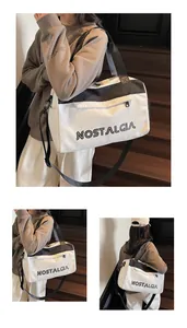 Close-up of black and white canvas travel bag with large NOSTALGIA print and wide strap
