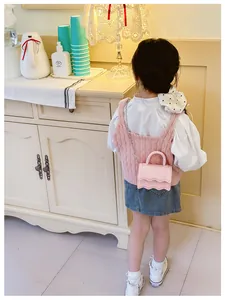 Détail du sac bandoulière rose en silicone pour enfant avec bord festonné et chaîne métal