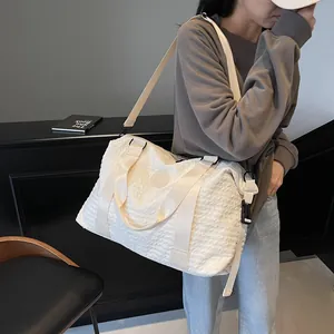 Large capacity off-white travel bag with textured fabric and adjustable shoulder strap