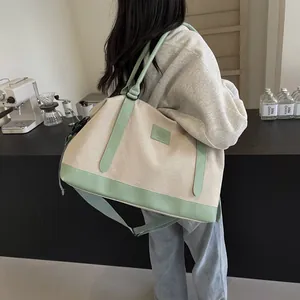 Large off-white canvas tote bag with light green leather trim and adjustable shoulder strap