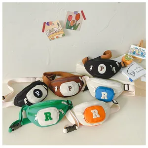Detailed view of kids canvas chest bags in multiple colors with plush letter patches