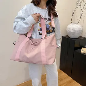 Dettaglio borsa da viaggio in nylon rosa con ricamo logo MORRO e ganci in metallo resistenti