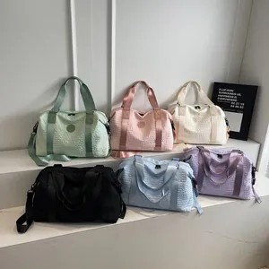 Detail view of large travel bags showing bubble texture fabric and multiple colors