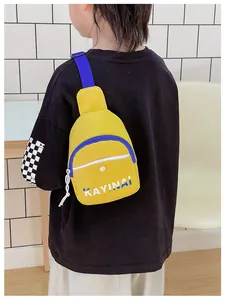 Détail du sac bandoulière jaune avec sangle bleue et design de lettres pour garçons