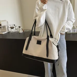 Minimalist off-white canvas tote bag with black leather straps and casual shoulder style