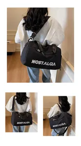 Detail of black sports duffel bag with NOSTALGIA print and adjustable shoulder strap