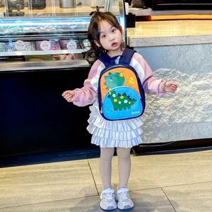 Zaino per bambini con dinosauro in colori a contrasto arancio e blu su modella