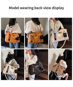 Close-up of stylish large travel tote bag featuring cat embroidery and plush pendant