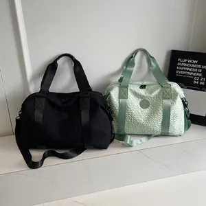 Detail view of large travel bags in black and mint green with wave texture and logo