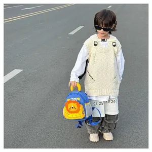 Detail of blue toddler lion backpack featuring side mesh pocket and yellow top handle