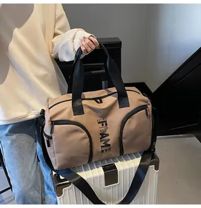 Dettaglio della borsa sportiva kaki con cinghie nere su una valigia bianca per viaggi