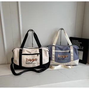 Detail view of large travel bag showing durable handles and the hope lettering print