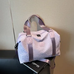 Detail of lavender textured travel bag showing wavy fabric and round logo emblem