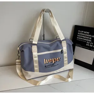 Close-up of contrast stitching and metal buckle on the blue and white travel tote bag