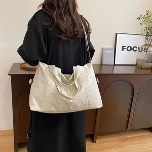 Borsa da viaggio capiente in nylon con tracolla regolabile e dettaglio del logo