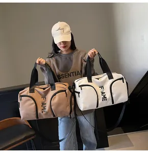 Dettaglio borsa sportiva con tasche multiple, tracolla regolabile e stampa di lettere