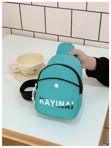 Détail du mini sac bandoulière sarcelle pour garçons avec lettrage KAYINAI noir et blanc