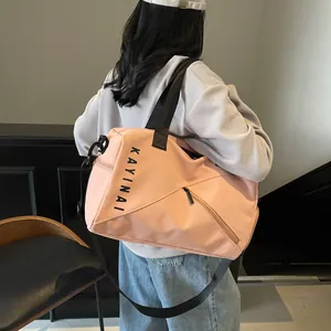 Detalle de bolsa de viaje rosa con logotipo y correa de hombro ajustable para el gimnasio