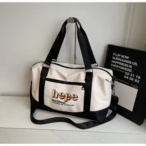 Detail of canvas travel bag with hope lettering, metal buckles and adjustable straps