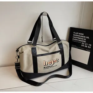 Close-up of khaki travel bag with hope lettering and adjustable black shoulder strap