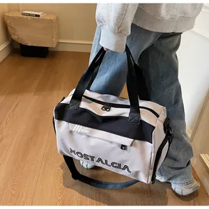Detail view of grey canvas duffel bag with black straps and side zipper pocket