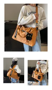 Detail of large nylon travel bag with logo strap and black plush cat pendant charm