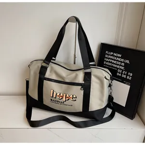 Detail of travel bag with reinforced handles, adjustable strap and front zipper pocket