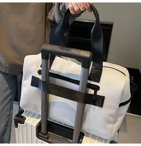 Borsa da viaggio bianca con fascia per bagaglio fissata al manico della valigia