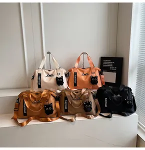 Five colorful large capacity travel bags displayed on tiered stands with cat charms