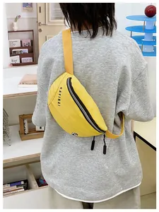 Lifestyle-opname van gele crossbodytas met verstelbare riem en logo op het model