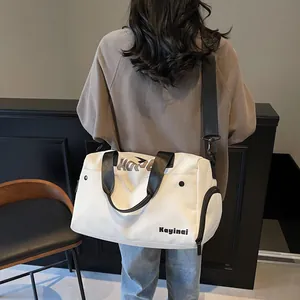 Achteraanzicht van model met grote witte reistas met zwarte riemen en een zijvak voor opslag