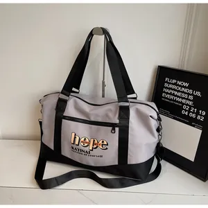Detail of grey travel bag with hope lettering and adjustable black shoulder strap