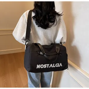 Close-up of model wearing black large capacity sports bag with NOSTALGIA print