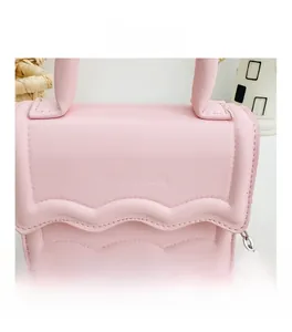 Détail du sac en cuir PU rose avec bords à volants et logo K doré sur le devant du sac