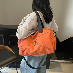 Detalle de bolsa de deporte naranja con separación seco-húmedo y compartimento lateral