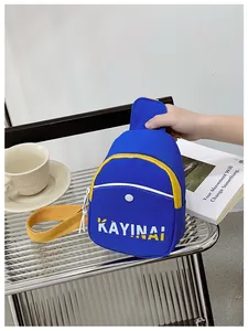 Détail de la sacoche bleue pour garçons avec bandoulières jaunes et logo sur table