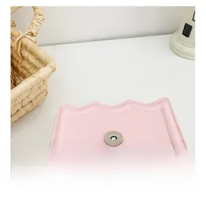 Détail du sac en similicuir rose avec rabat festonné et fermoir magnétique