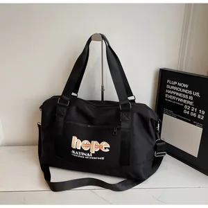 Detail view of large capacity travel bag with hope lettering and front zipper pocket