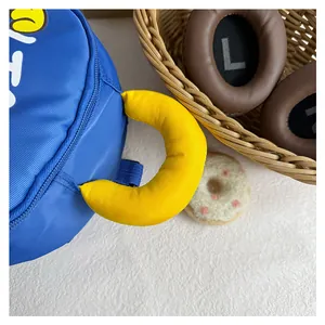 Detail of blue nursery backpack featuring a soft yellow padded handle and vibrant fabric