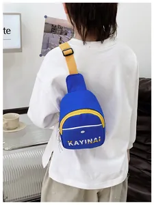 Détail du sac bandoulière bleu pour garçons avec fermeture éclair jaune et logo au dos