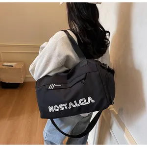Macro view of a black gym bag with white lettering and a side zipper compartment