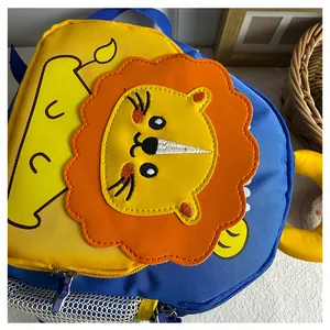 Close-up of cute cartoon lion design and embroidery details on a yellow nursery backpack